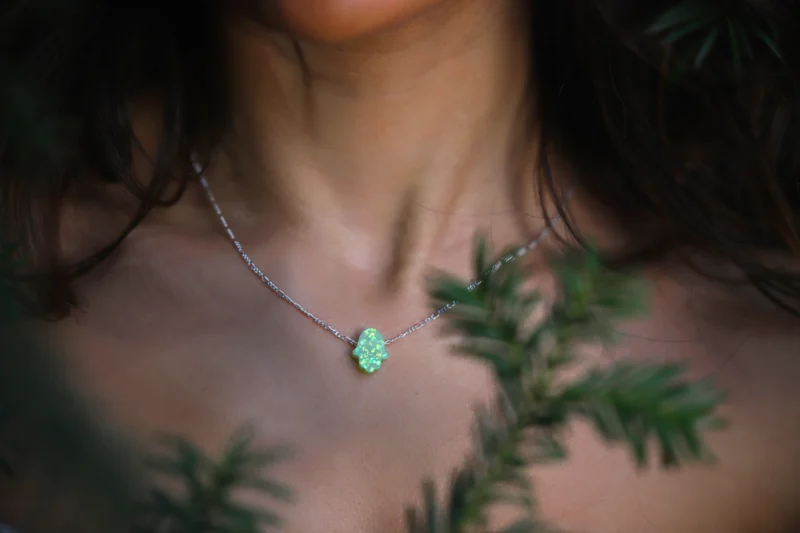 collier main fatma vert sous un sapin